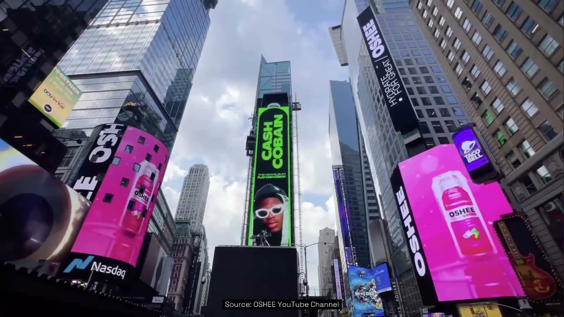 OSHEE Sparkling Water pink billboards among the Nasdaq tower and surrounding jumbotron screens in Times Square, New York, looking up at the skyscrapers